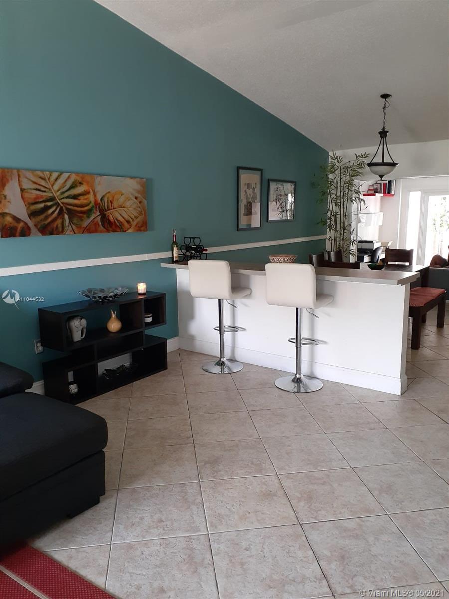 1404 Southwest 104th Court, Unit 89B Miami, FL 33174 - Photo 19 of 29 a living room with furniture a fireplace and a flat screen tv
