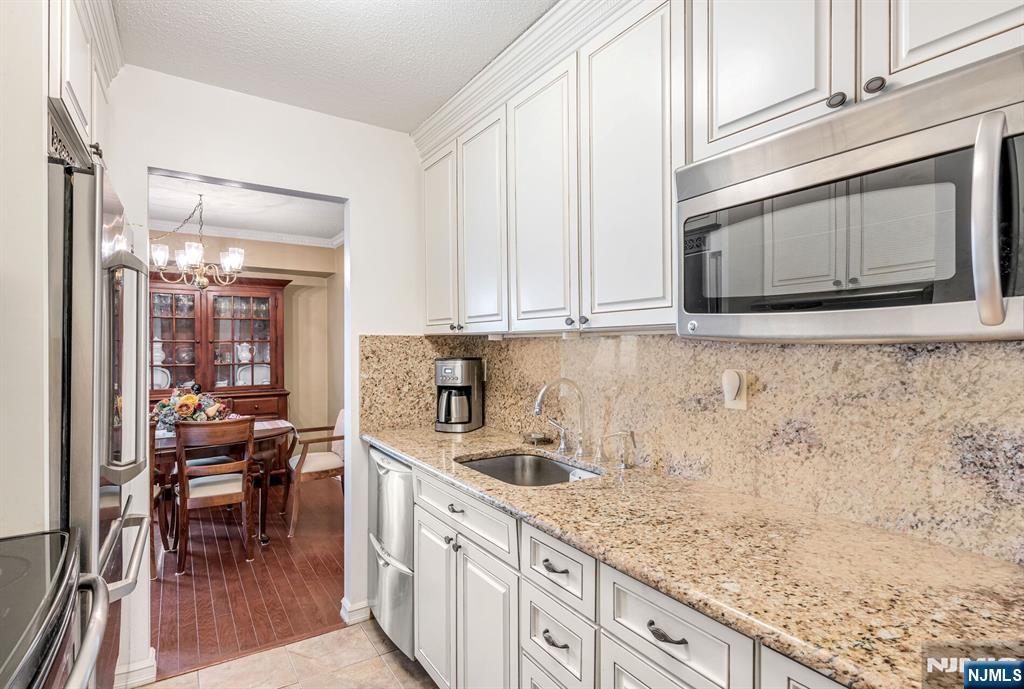 125 Prospect Avenue, Unit 16C Hackensack, NJ 07601 - Photo 20 of 35 a kitchen with stainless steel appliances granite countertop a stove a sink and a microwave