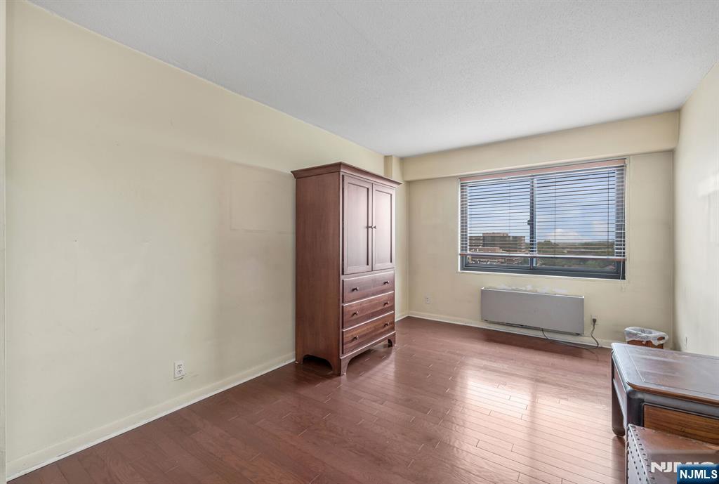 125 Prospect Avenue, Unit 16C Hackensack, NJ 07601 - Photo 27 of 35 a view of an empty room with a window and wooden floor