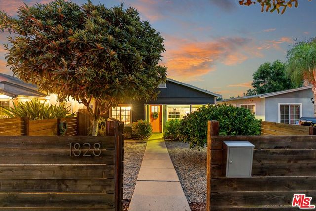 a view of a patio with table and chairs with wooden floor and fence