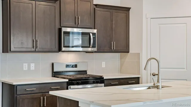 a kitchen with stainless steel appliances granite countertop a stove a microwave and cabinets