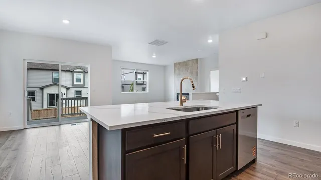 a kitchen with a sink a counter space and wooden floor