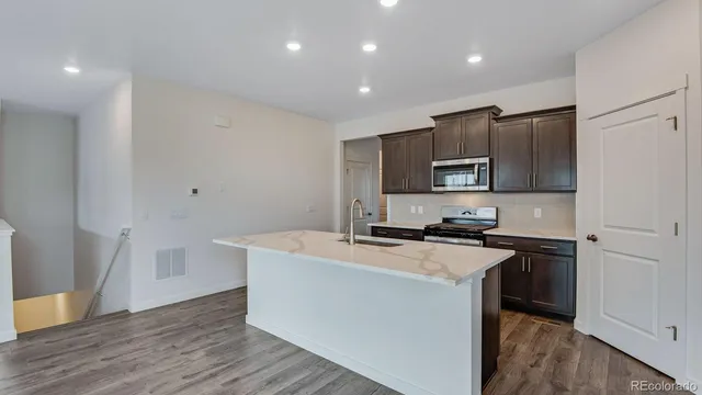 a kitchen with a stove a sink and a refrigerator