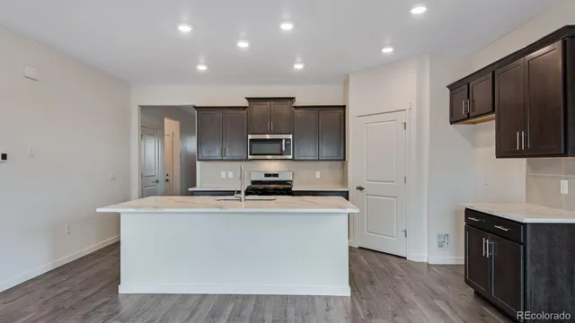 a kitchen with stainless steel appliances a sink stove top oven and refrigerator