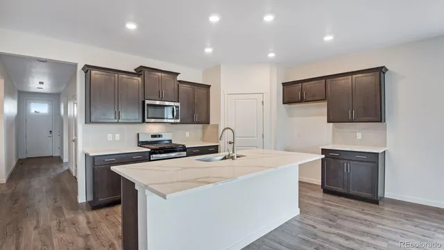 a kitchen with kitchen island a sink stainless steel appliances and cabinets