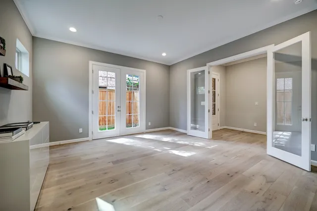 a view of an empty room with window and wooden floor