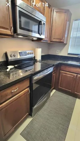 a kitchen with stainless steel appliances granite countertop a stove microwave and sink