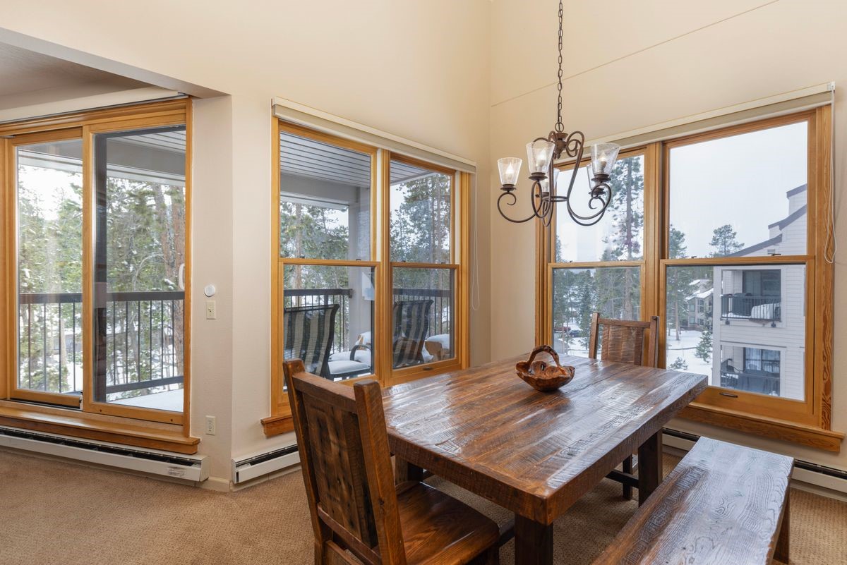 240 Tennis Club Road, Unit 1664 Keystone, CO 80435 - Photo 5 of 26 Carpeted dining area featuring a baseboard heating unit, a chandelier, and a healthy amount of sunlight