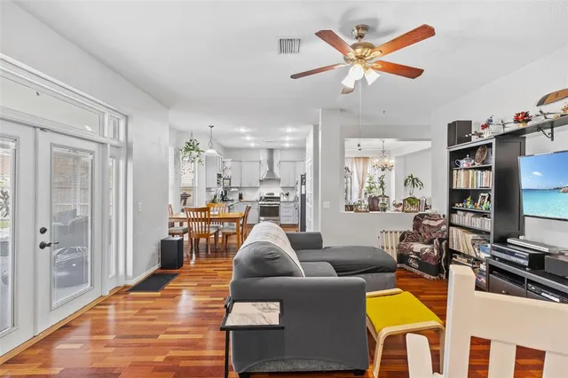 a living room with furniture kitchen view and a large window