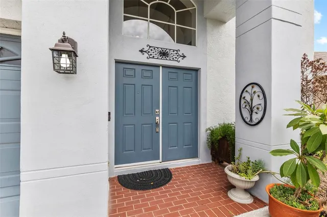 a front view of a house with garden and tree
