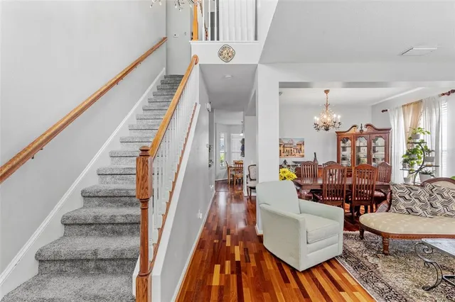 a kitchen with stainless steel appliances a dining table chairs stove refrigerator and cabinets