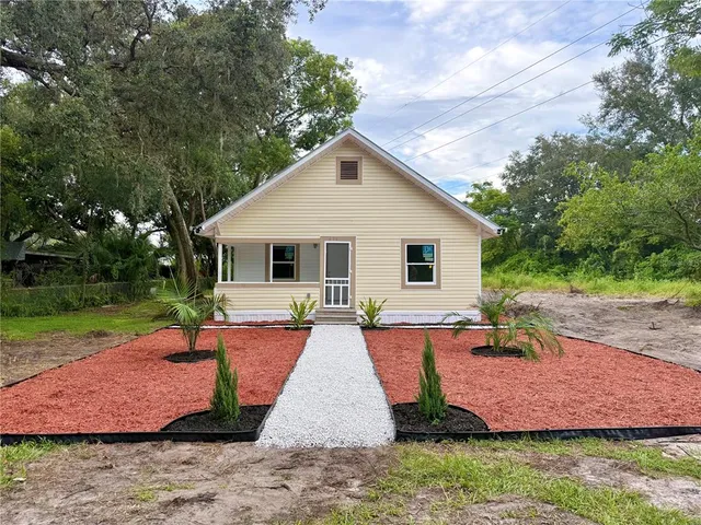 a view of a house with backyard and sitting area