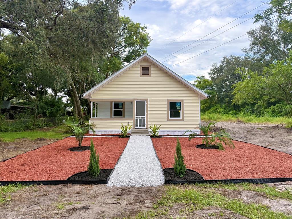 a view of a house with backyard and sitting area