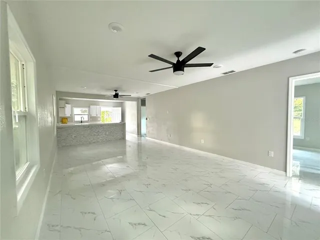 a view of a big room with wooden floor and a ceiling fan