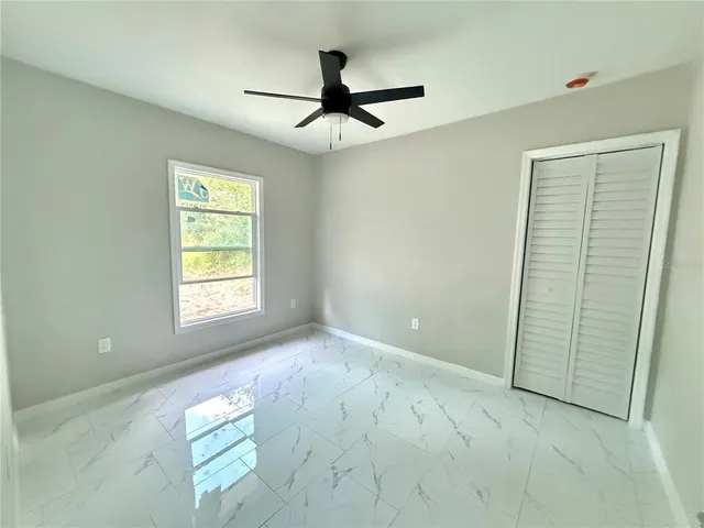 a view of empty room with ceiling fan