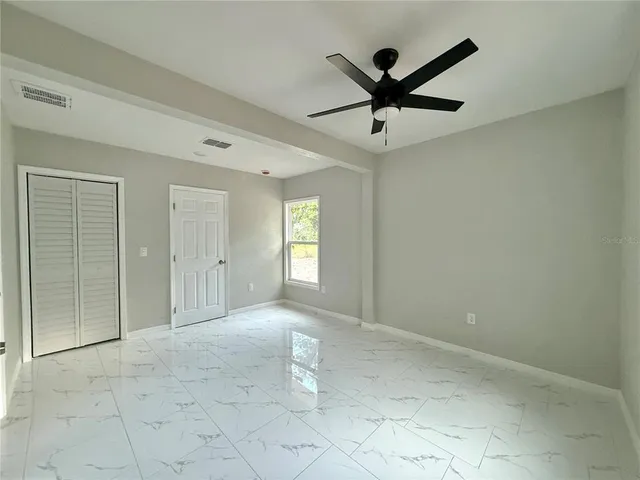 a view of a livingroom with a ceiling fan and window