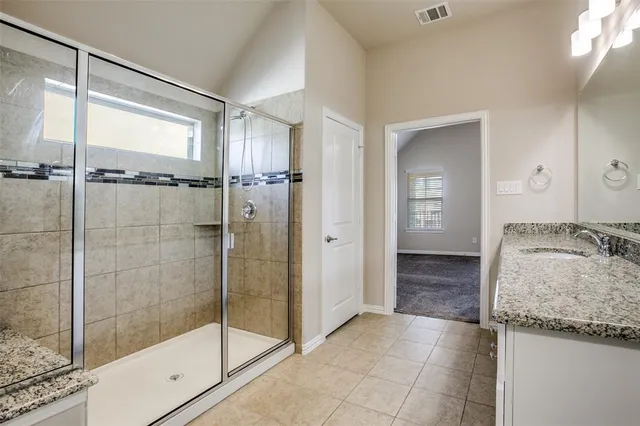 a bathroom with a granite countertop sink and shower