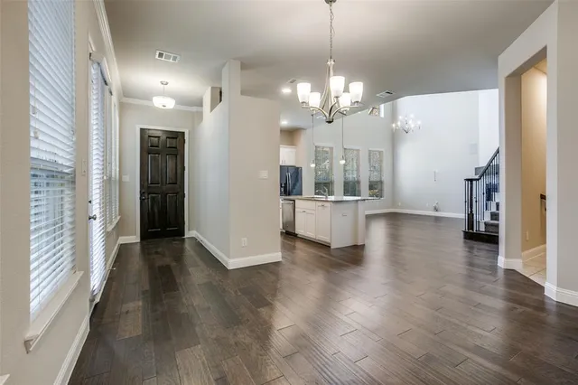 a view of a big room with wooden floor and a kitchen