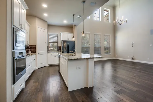 a kitchen with stainless steel appliances a refrigerator sink and cabinets