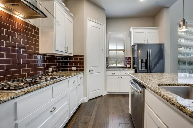 a kitchen with granite countertop a sink stove and cabinets