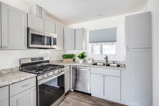 a kitchen with granite countertop a sink stove and cabinets