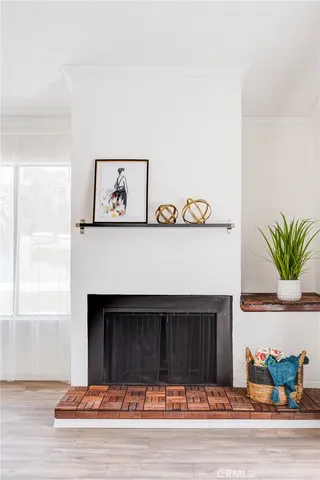 a living room with a fireplace and potted plant on the counter