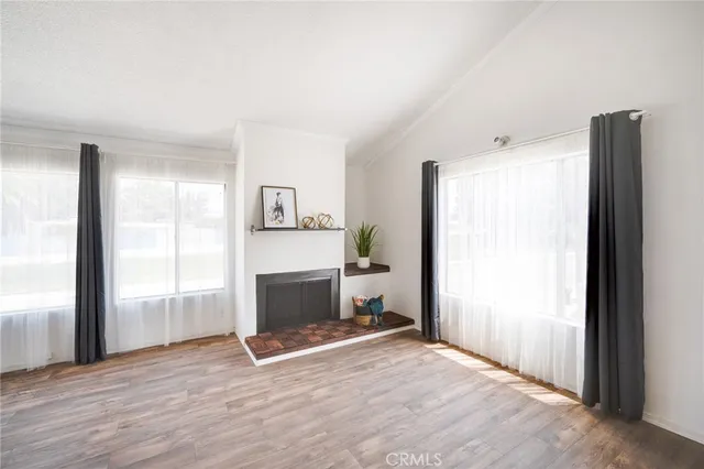 a view of empty room with wooden floor and fireplace