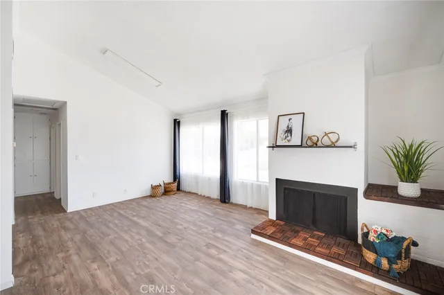 a view of empty room with wooden floor and fireplace