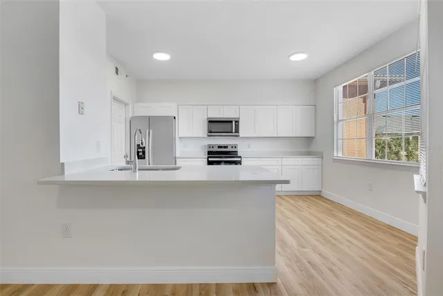 a kitchen with stainless steel appliances granite countertop a stove a sink and a microwave