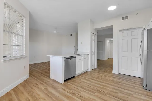 a view of a kitchen with wooden floor and electronic appliances