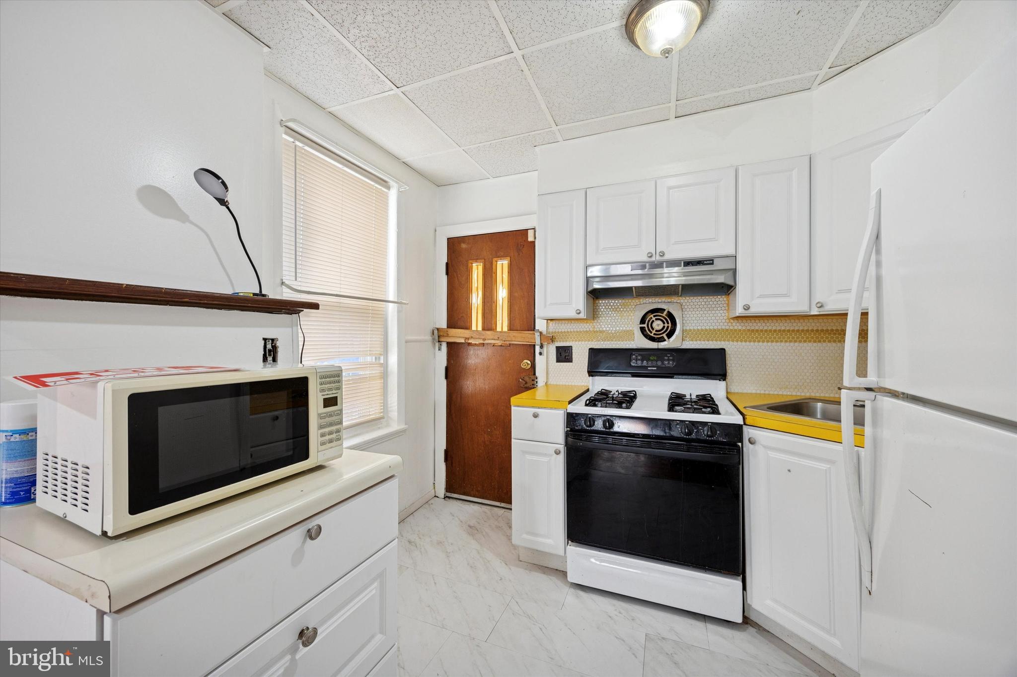 6340 Theodore Street Philadelphia, PA 19142 - Photo 8 of 15 a kitchen with a stove and a microwave