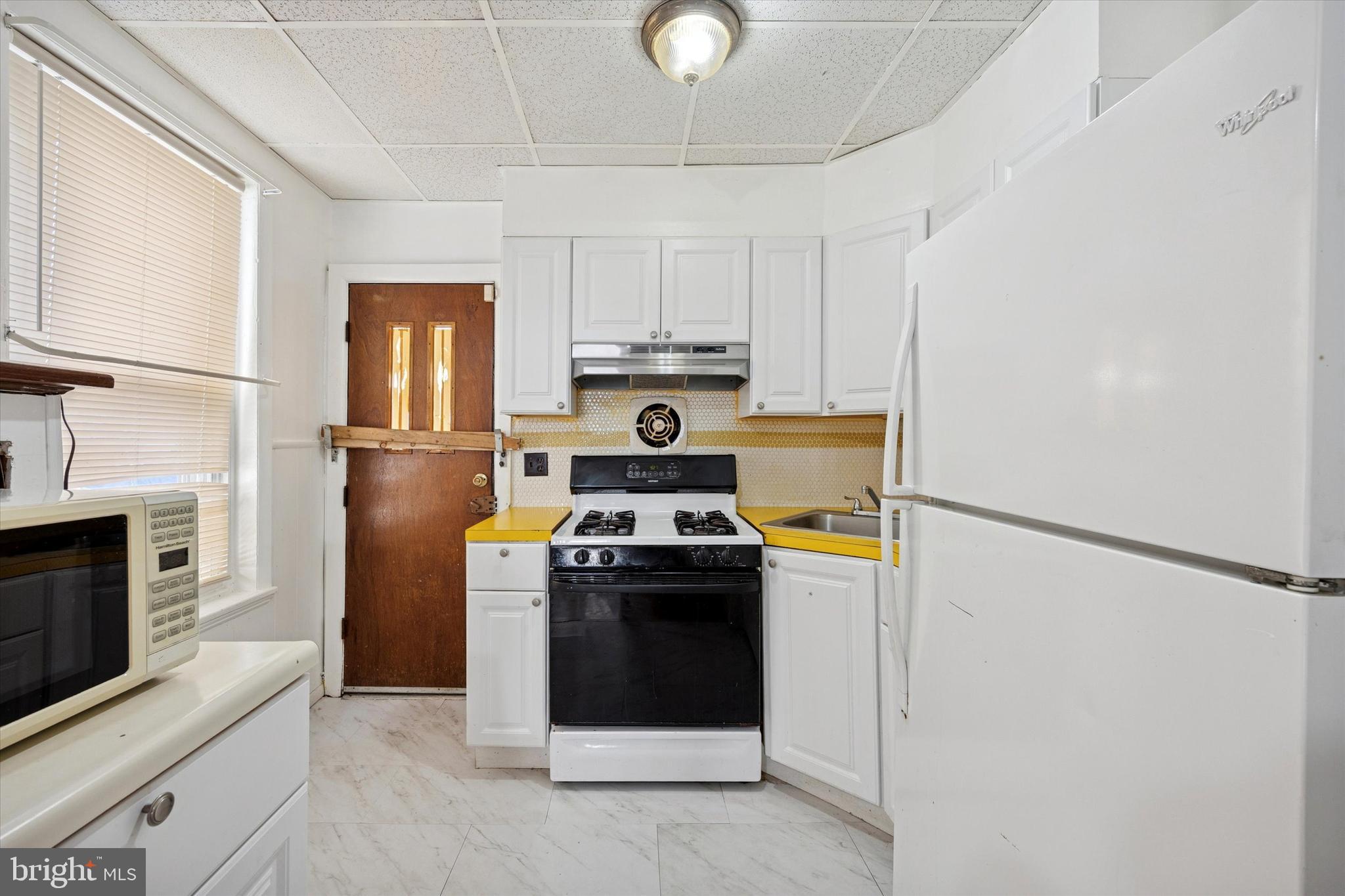 6340 Theodore Street Philadelphia, PA 19142 - Photo 9 of 15 a kitchen with a stove top oven and refrigerator