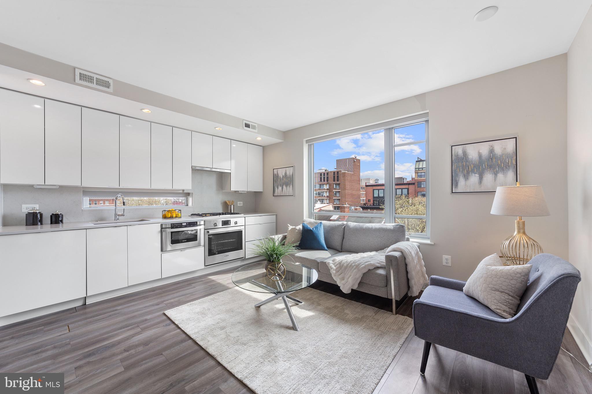 a living room with furniture white walls and wooden floor