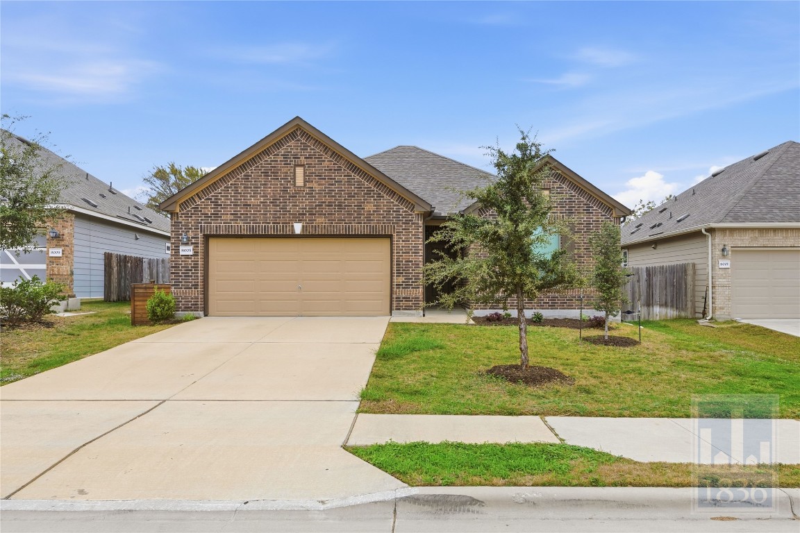 a front view of a house with a yard and garage