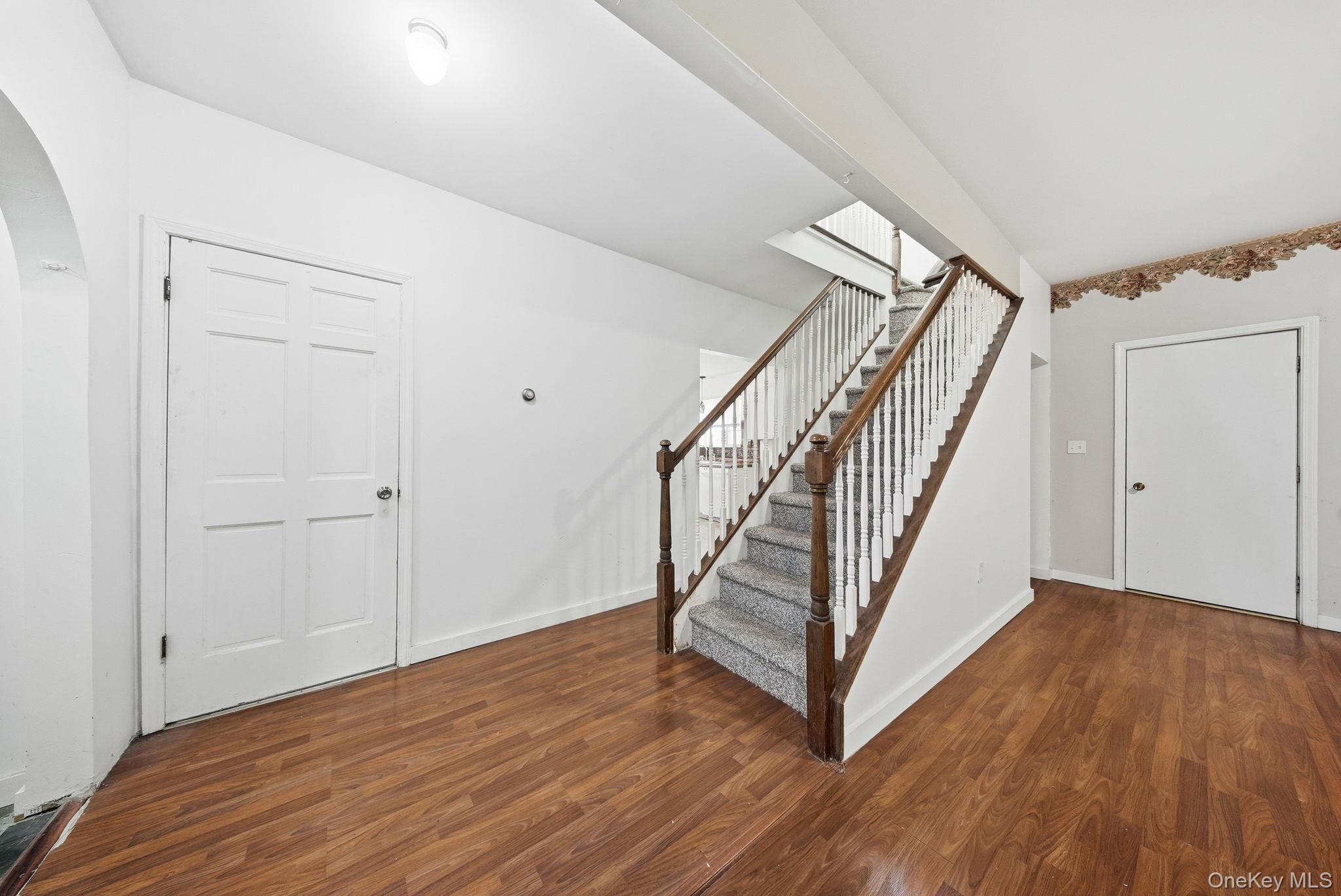 21 Ridge Street Middletown, NY 10940 - Photo 11 of 32 Entrance foyer with stairway, dark wood-style floors, and arched walkways