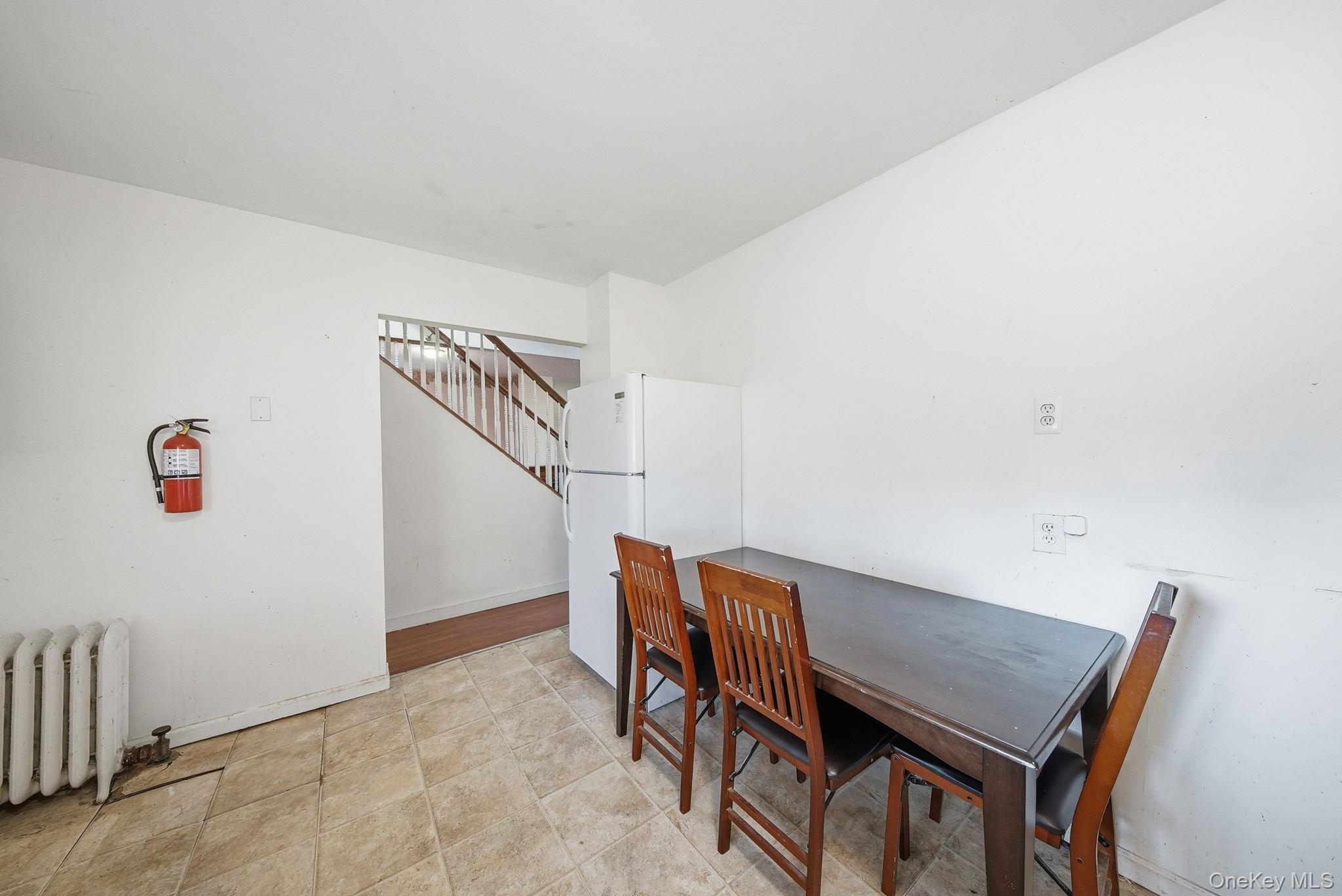 21 Ridge Street Middletown, NY 10940 - Photo 13 of 32 Dining room featuring radiator and stairway