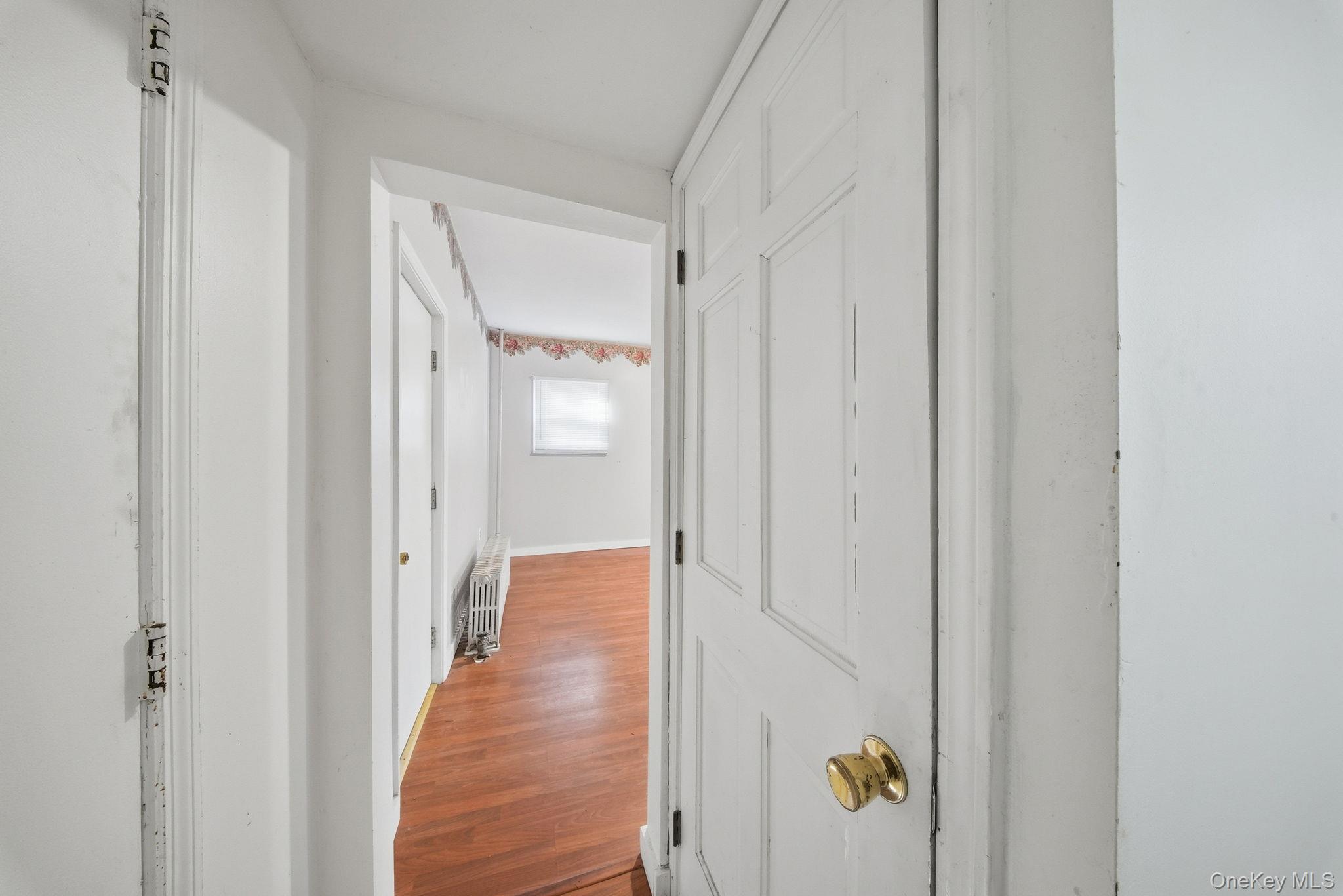21 Ridge Street Middletown, NY 10940 - Photo 14 of 32 Corridor with wood finished floors and radiator heating unit