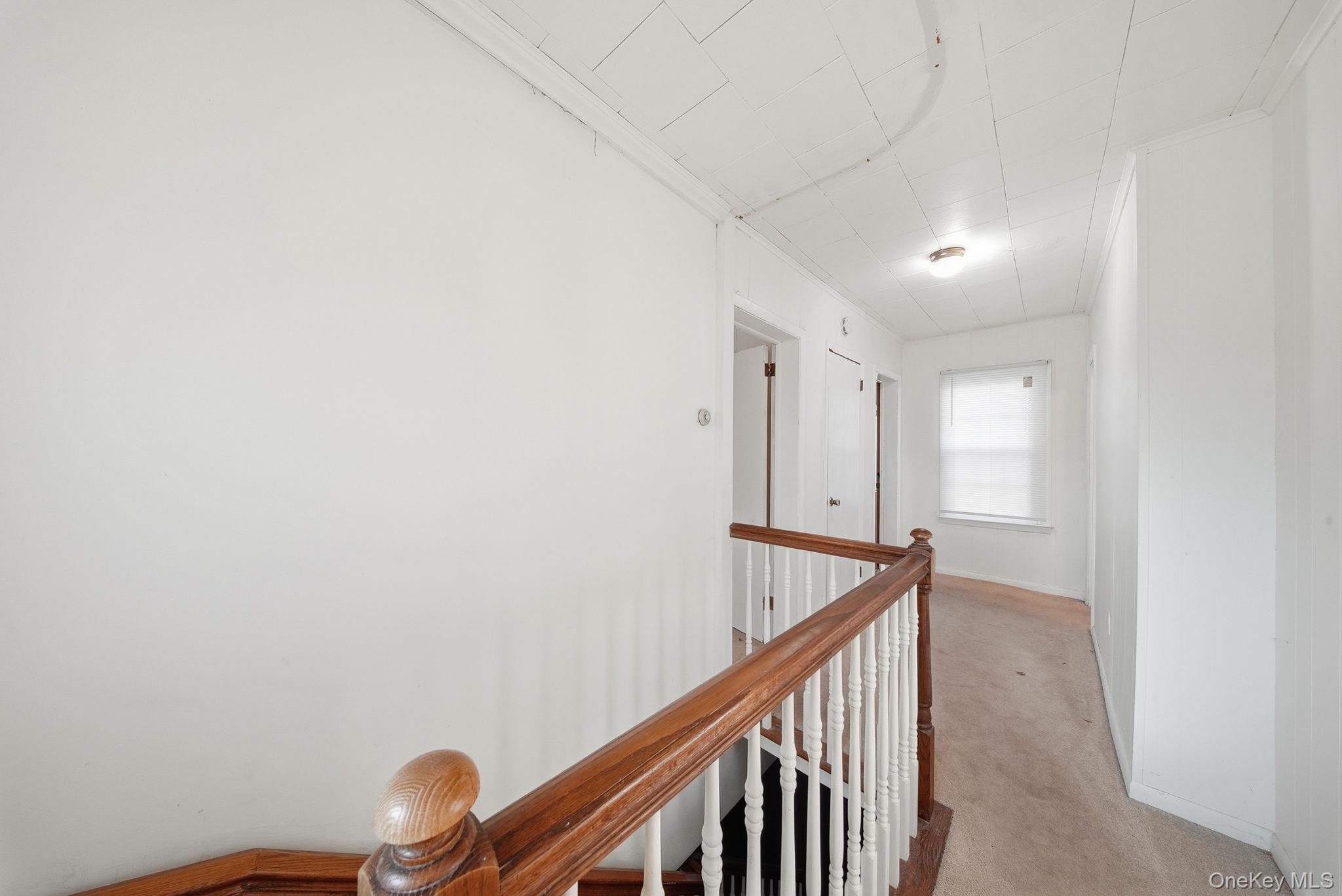 21 Ridge Street Middletown, NY 10940 - Photo 20 of 32 Hallway with an upstairs landing, light colored carpet, and crown molding