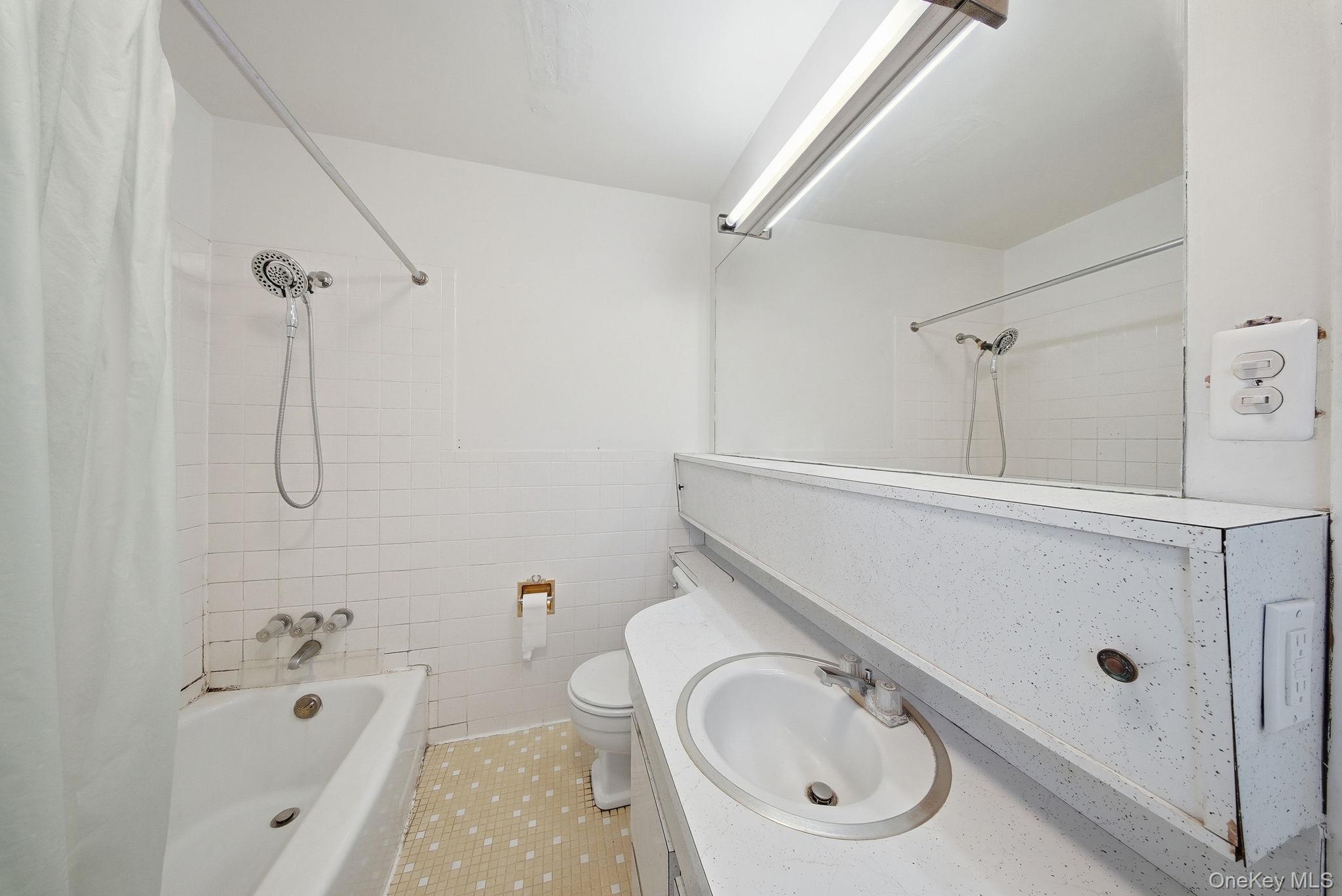 21 Ridge Street Middletown, NY 10940 - Photo 23 of 32 Bathroom with vanity, tile walls, shower / tub combo with curtain, and tile patterned flooring