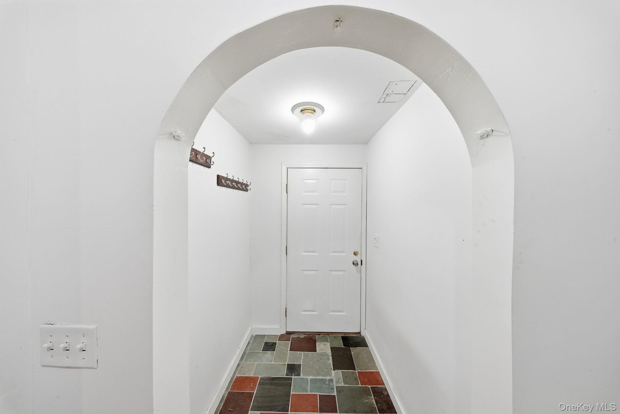 21 Ridge Street Middletown, NY 10940 - Photo 5 of 32 Doorway to outside with arched walkways and stone tile flooring