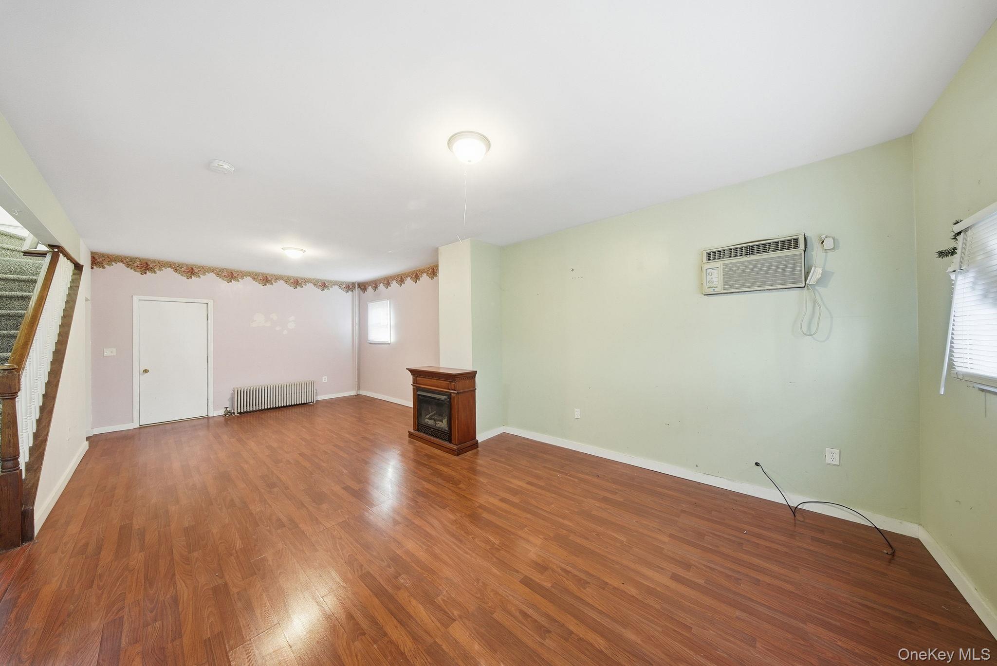 21 Ridge Street Middletown, NY 10940 - Photo 8 of 32 Large living room with a space to a dining room table & a wall mounted AC