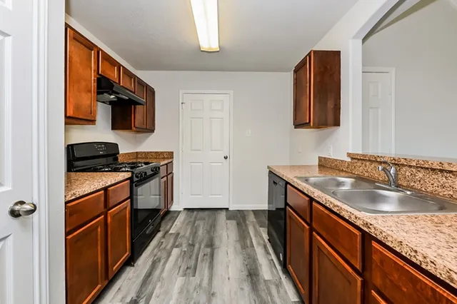 a kitchen with stainless steel appliances granite countertop a sink stove and refrigerator