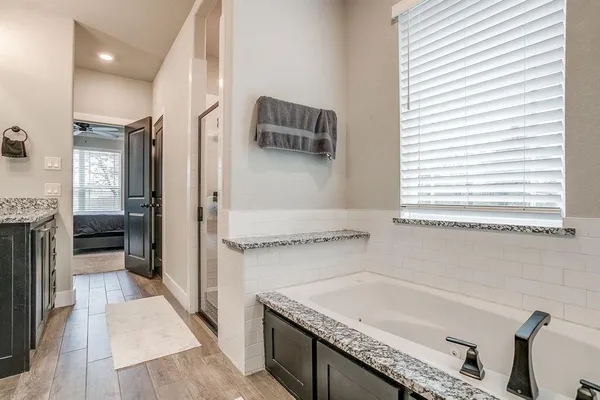 a bathroom with a granite countertop sink a mirror and shower