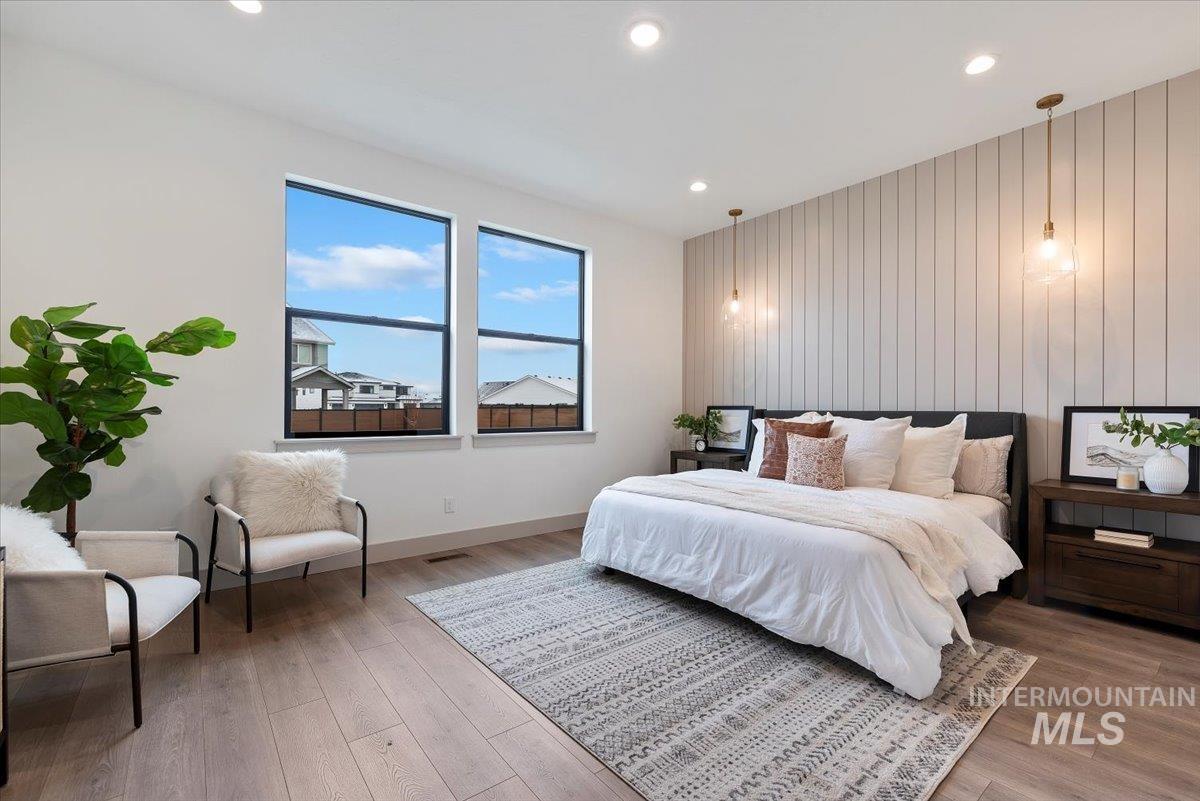 8458 West Graye Street, Unit RAINIER Meridian, ID 83646 - Photo 15 of 29 Bedroom with an accent wall, light wood-style flooring, recessed lighting, and wood walls