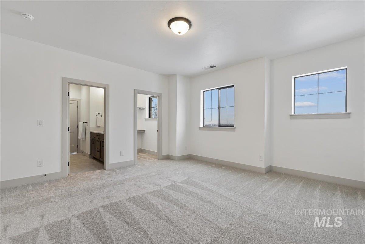 8458 West Graye Street, Unit RAINIER Meridian, ID 83646 - Photo 21 of 29 Unfurnished bedroom with a walk in closet, light carpet, and ensuite bath