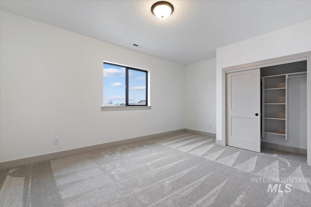 8458 West Graye Street, Unit RAINIER Meridian, ID 83646 - Photo 25 of 29 Unfurnished bedroom featuring light colored carpet and a closet