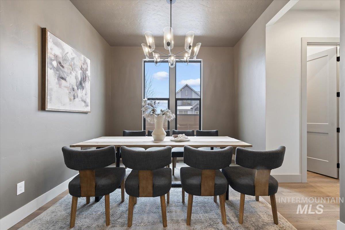 8458 West Graye Street, Unit RAINIER Meridian, ID 83646 - Photo 5 of 29 Dining room featuring hanging lights, light wood-style flooring, and a textured ceiling