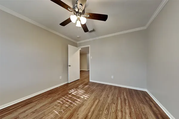 a view of a room with wooden floor and ceiling fan