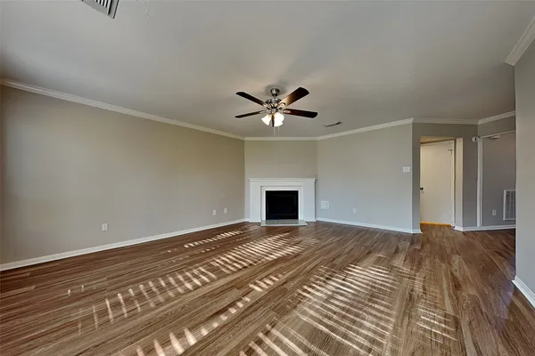 a view of an empty room with a ceiling fan and a window