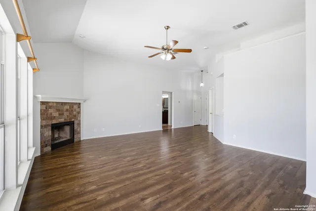 a view of empty room with wooden floor and fireplace